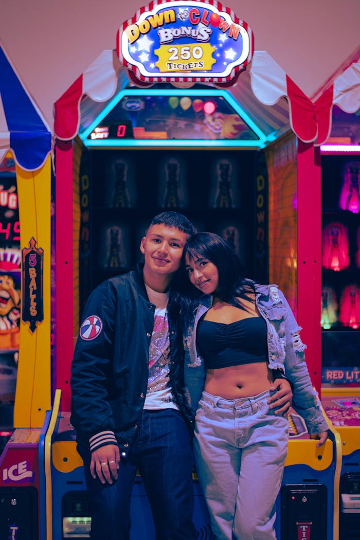 Happy couple in an arcade enjoying games and each other's company under neon lights.
